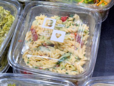 Plastik kabın içinde sebzeli taze fusilli makarna salatası..
