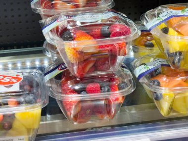 Sergilenen plastik kaplarda taze meyve ve tropikal meyveler..