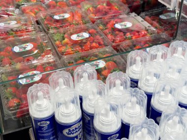 Süpermarket vitrininde taze çilek ve krem şanti kutuları..