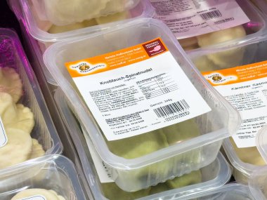 Süpermarket vitrininde plastik Knoblauch spinatnudel kapları.