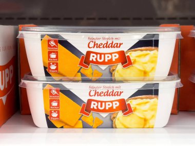 Paketlenmiş çedar peyniri rafta sergileniyor.