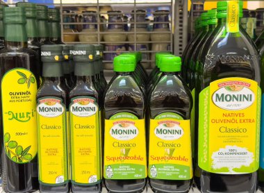 Market raflarında çeşitli zeytinyağı şişeleri sergilenmektedir..