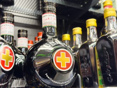 Unicum bitkisel likör şişeleri özel etiketlerle dolu bir rafta..