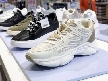 Ayakkabı mağazasında şık spor ayakkabıları sergileniyor.