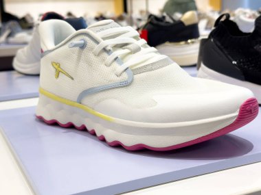 Mağaza ortamında beyaz ve pembe spor ayakkabı görüntüsü.