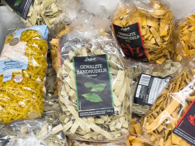Rafta gösterilen çeşitli paketlenmiş makarna çeşitleri.