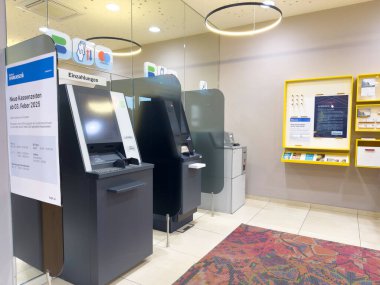 Bilgilendirici ekranları olan modern bir banka içi bankamatik makineleri.