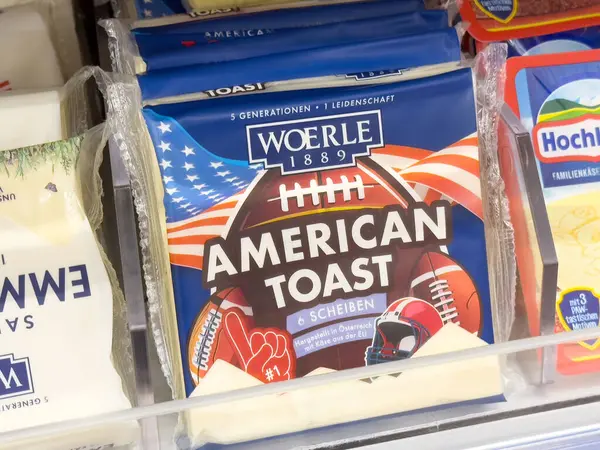 Süpermarket vitrininde Amerikan tost peyniri paketleri ve futbol temalı ambalajlar.