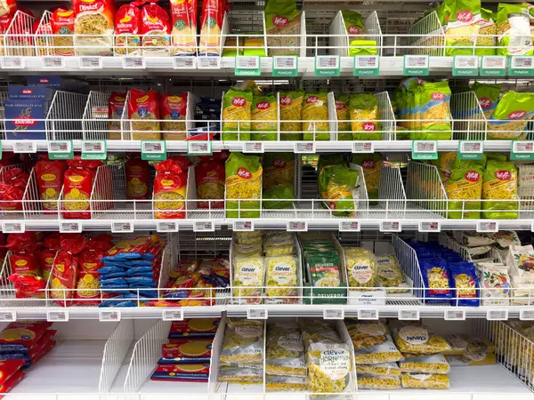 Market rafında değişik şekil ve renklerde çeşitli makarna paketleri var..