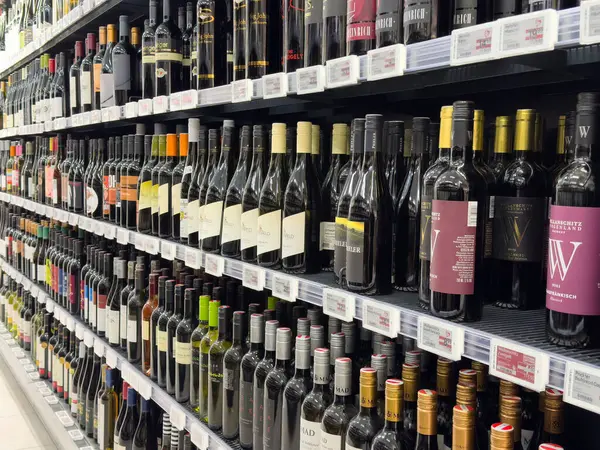 Süpermarket raflarında geniş şarap şişeleri seçimi.