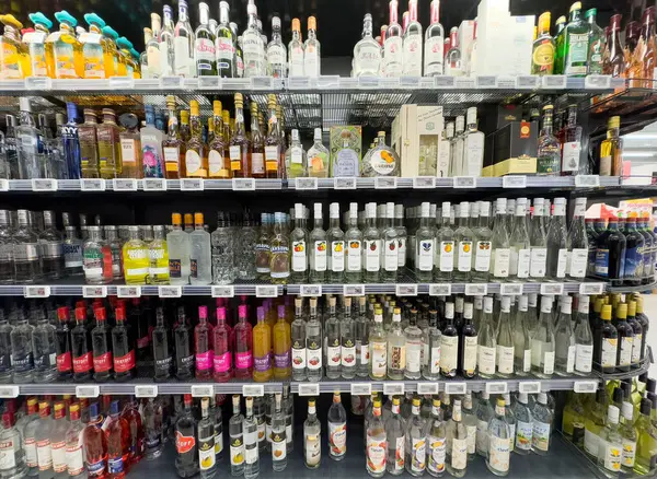 Mağaza raflarında çeşitli alkol seçimleri: votka, viski, rom, tekila, cin vitrini.