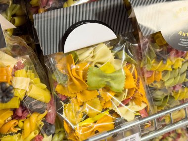 Markette şeffaf ambalajlarda çeşitli makarna şekilleri gösterilir.