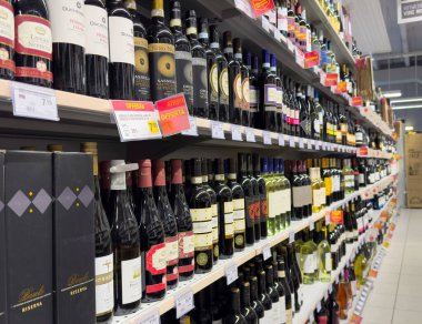 Süpermarket koridorunda şarap seçimi ve raflarda çeşitli şişeler.
