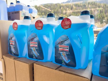 Mavi cam yıkama sıvısı şişeleri otomotiv mağazasında sergileniyor.