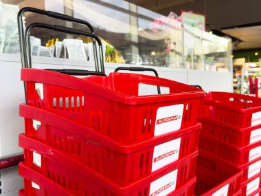 Süpermarketin iç kısımlarında kasaları olan kırmızı alışveriş sepetleri..