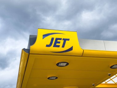 Jet benzin istasyonu bulutlu gökyüzünün altında koyu sarı damgalı..