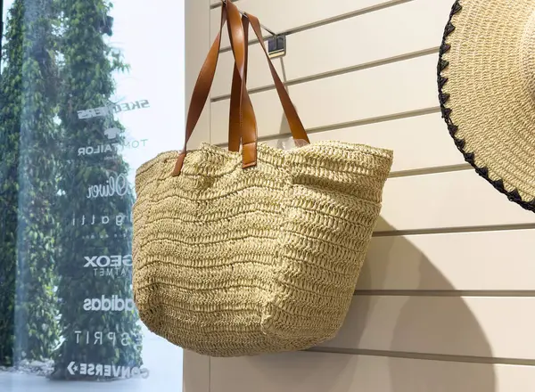 Rafta kahverengi deri saplı el yapımı saman torbası..