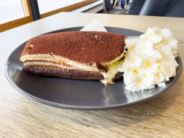 Lezzetli bir dilim tiramisu ve krem şanti..
