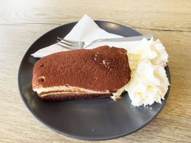 Gri tabakta krem şantili nefis tiramisu dilimi..