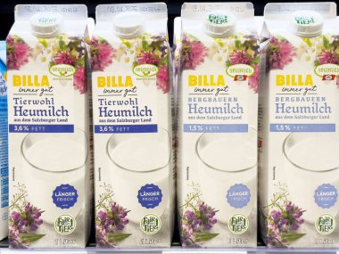 Çiçek tasarımı ve tazelik etiketli Billa süt kutuları sergileniyor.
