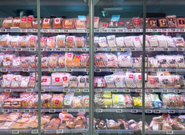 Market koridorunda sergilenen paketlenmiş ekmek somunlarının çeşitliliği.