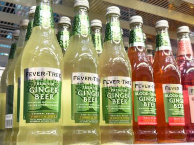 Rafta duran ateş ağacı zencefilli bira şişeleri köpüklü içecek seçimi sergiliyor.