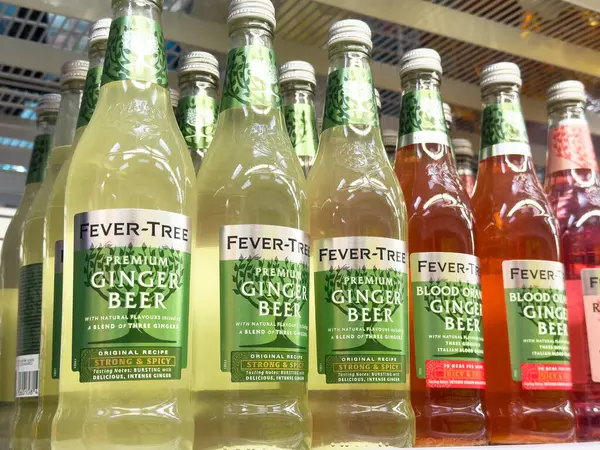 Rafta duran ateş ağacı zencefilli bira şişeleri köpüklü içecek seçimi sergiliyor.