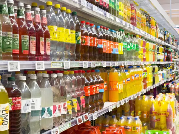Markette çeşitli içecekler içeren renkli soda reyonu.