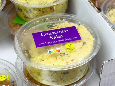 Paprikalı kuskus salatası ve şeffaf plastik kabın içinde kuru üzüm..