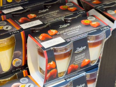 Süpermarkette sergilenen çilek katmanlı tatlılar, etiketli plastik bardaklarla paketlenmiş.
