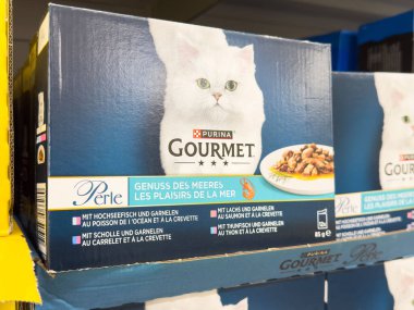 Purina gurme kedi maması kutusu beyaz kedi ve deniz ürünleri görüntüsü sergileniyor..