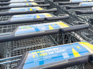 Marketin otoparkında reklam panelleri olan süpermarket alışveriş arabaları..