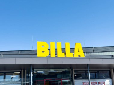 Şehir ortamında açık mavi gökyüzü arkaplanına sahip Billa mağaza önyüzü.