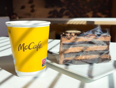 Kahve fincanı ve çikolatalı kek, kafe masasının üzerinde..