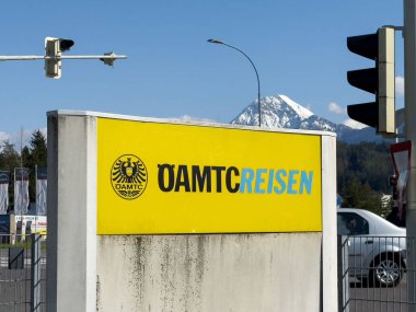 Güneşli bir günde yansıyan arabaları ve amblemi olan oamtc binası..