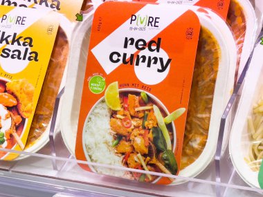 Beyaz pirinç ve sebzelerle ambalajda kırmızı köri yemeği süpermarkette sergileniyor..