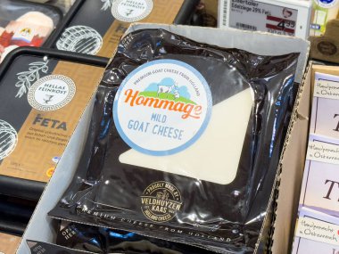 Süpermarket süt ürünleri bölümünde hafif keçi peyniri paketi.