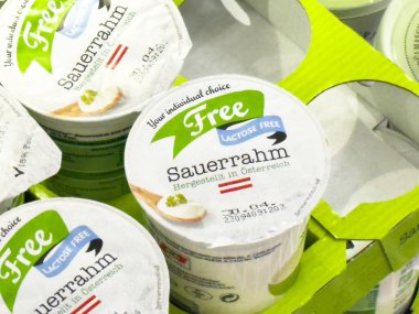 Süpermarkette son kullanma tarihi olan laktozsuz sauerrhm paketleme.