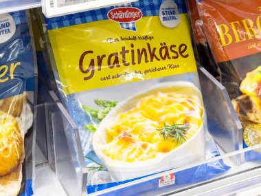 Süpermarket buzdolabı rafında sergilenen paketlenmiş graten peyniri.