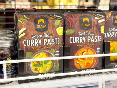 Süpermarket raflarındaki Tayland köri macunu paketlerinin çeşitliliği.