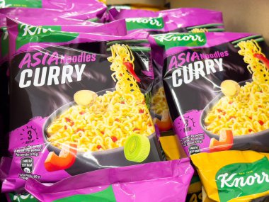 Bakkal vitrininde canlı ambalajlı köri aromalı erişte paketleri.