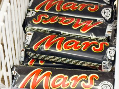 Mars çikolatalarının rafında kırmızı logo olan görüntüsü.