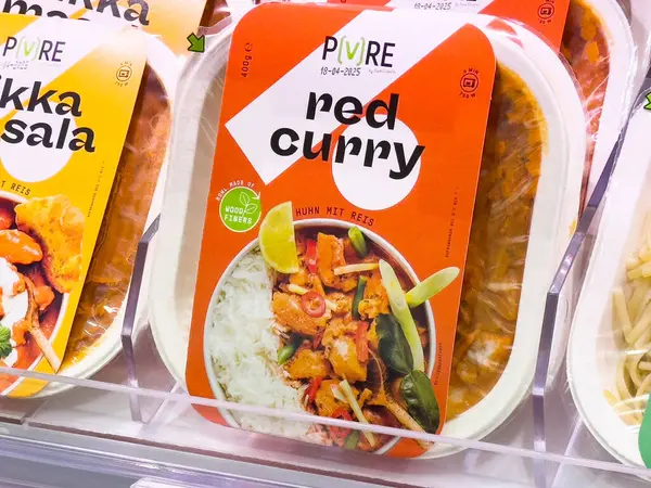 Beyaz pirinç ve sebzelerle ambalajda kırmızı köri yemeği süpermarkette sergileniyor..