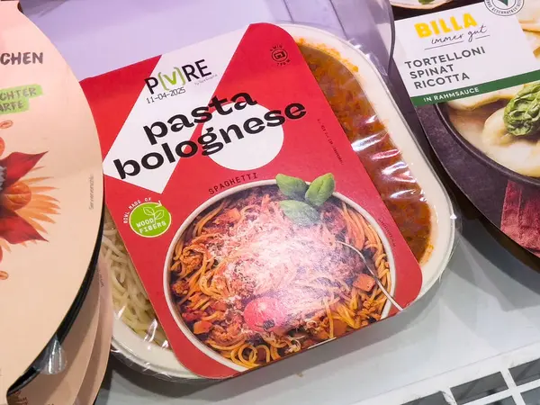 Plastik kabın içinde spagetti ve domates sosuyla paketlenmiş makarna..