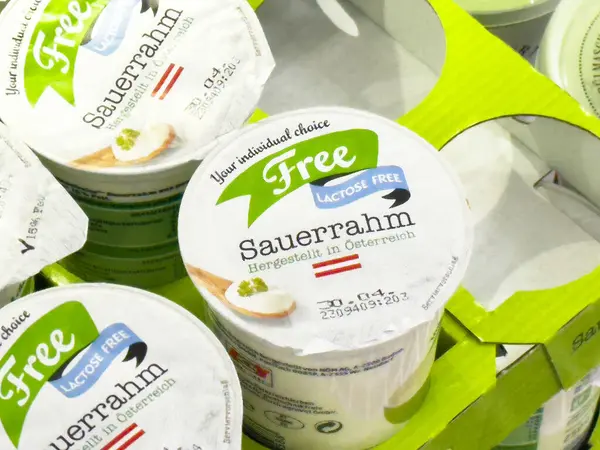 Süpermarkette son kullanma tarihi olan laktozsuz sauerrhm paketleme.
