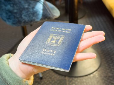 Kafe ortamında İsrail pasaportu elinde..