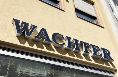 Kapalı pencereli bej bina dış kısmında Wachter mağaza önü tabelası.