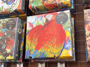 Raflarda gösterilen renkli papağan yapbozu.