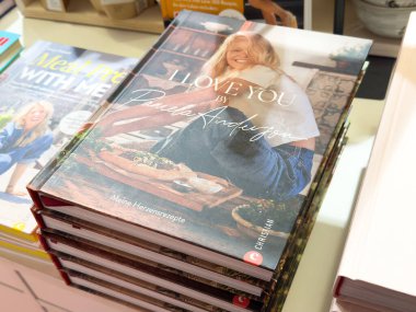 Yemek kitabı kapağındaki gülümseyen kadın yazar kitapçıda sergilendi.