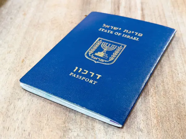 Ahşap yüzeyde amblem ve metinle mavi İsrail pasaportu..